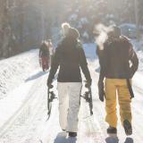 Group of friends walking with snowshoes in hand