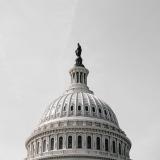 U.S. Capitol dome against gray sky. (Photo by Alejandro Barba on Unsplash)