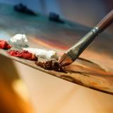 Artist dips brush in paint
