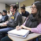 Students listen to lecture in a large classroom