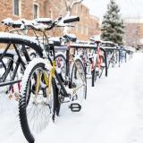 Snow-covered bikes on a rack on campus