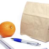 Brown bag, notebook, pen and an orange