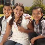 Two brothers and sister ready for school with backpacks on | Photo credit BUENO Center