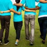 Group of in teal shirts walking arm in arm