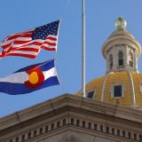 U.S. and Colorado state flags fly at the Colorado state capitol building