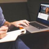 Man watches video with captions on Macbook