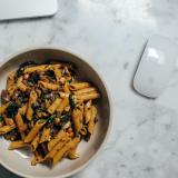 bowl of pasta sitting next to laptop and mouse