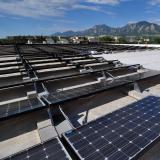 A technician installs solar panels on the roof of the building which houses the University of Colorado Center for Innovation and Creativity in Boulder. 