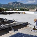 Brandon Bell, a technician from Lighthouse Solar, installs solar panels on the roof of the building which houses the University of Colorado Center for Innovation and Creativity in Boulder.