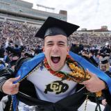 Graduate pulls a Superman, exposing a CU Buffs shirt under his robe