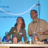 Two faculty members present an electrical light-based experiment.