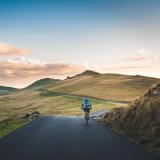 Stock image of a person riding a bike over hills