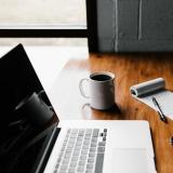 laptop, coffee and notepad at a desk