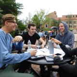 students sitting at a table outside on campus