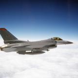 F-16C block 25 aircraft flying above the clouds