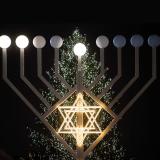 a large menorah in front of a Christmas tree at the Brandenburg Gate in Berlin, Germany