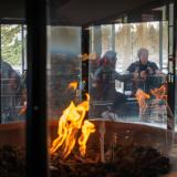 Students sit inside near a fire in the WeatherTech Cafe