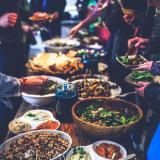 People serve themselves food buffet-style at a dinner party