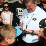 Coach Mike MacIntyre autographs a fan's hat