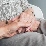 Two older people holding hands