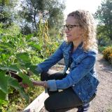 Professor Jill Litt looks over an eggplant at a community garden next to Regis University in Denver