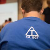 student wearing a blue T-shirt with the Triangle fraternity symbol