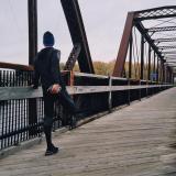 Runner stretches on pedestrian bridge
