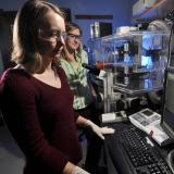 Graduate students work in microscope lab studying tissue cells