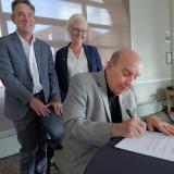 Patrick O’Rourke and Jessica Doty overlook Chancellor Phil DiStefano signing the Okanagan Charter