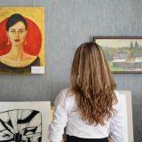 A woman looking at paintings