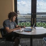 Student-athlete Philip Lindsay studying in club overlooking Folsom Field