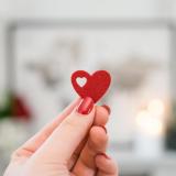 Person holding a red felt heart