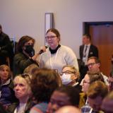 Campus community member asks a question during a conference keynote session