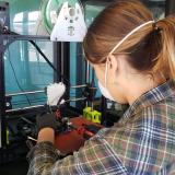 Rachel Sharpe conducts repairs on a 3D printer.