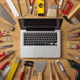 Stock image of a laptop computer surrounded by tools