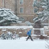 Student walking across campus in the snow.