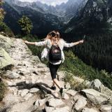 Woman frolics down rocky, mountainous path