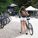 Student walking their bike toward a rack on campus