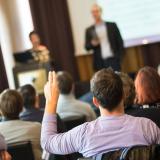 Man raises hand in town hall event