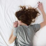 A stock photo of a woman sleeping on a bed