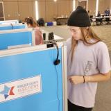Student voting in a booth on campus