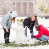 Students building a snowman on campus