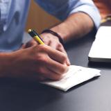 Person writes in notebook during workshop