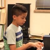 Child plays piano during lesson