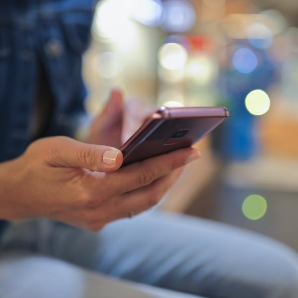 Hand holding a purple smartphone