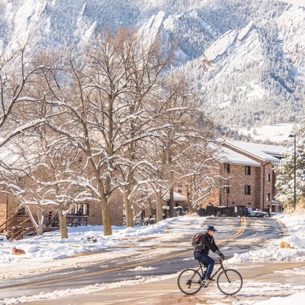 person riding a bike on a snowy campus
