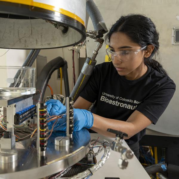 Amrita Singh working with a vacuum chamber