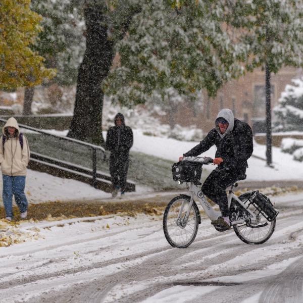person riding a bike on snowy campus