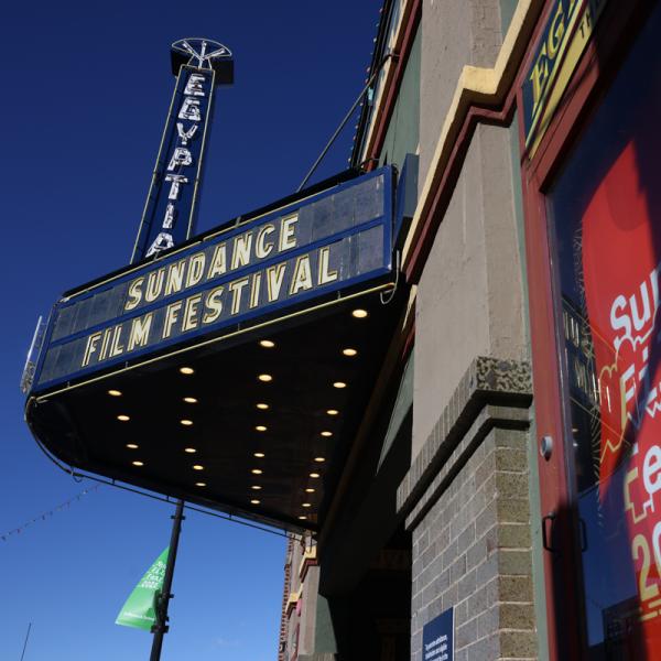 A photo of a marquee display and poster outside a theater. Text on the marquee and poster reads Sundance Film Festival.