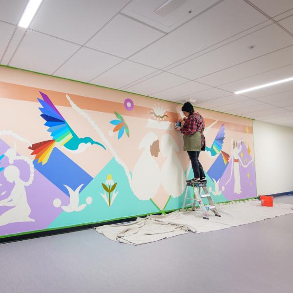 Danielle SeeWalker painting a mural